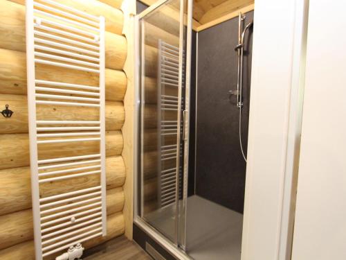 a shower in a bathroom with a wooden wall at Jenig 4B in Jenig