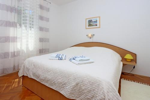 a bedroom with a bed with two towels on it at Family-friendly apartments with swimming pool Banjol, Rab - 5007 in Rab