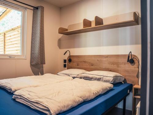 a bed with two pillows on it in a room at Timber-Lodge in Vessem