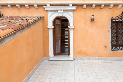 an orange building with a door and a balcony at Charming Palace Corte del Teatro in Venice