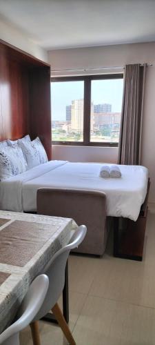 a hotel room with a large bed and a window at Cozy33 The Persimmon Studio, Near Airport, SM, Ayala, Cebu Business Park, Cebu IT Park in Cebu City