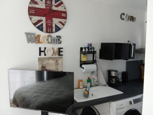 ein Schlafzimmer mit einem Bett, einem Schreibtisch und einer Uhr in der Unterkunft studio, in Doue