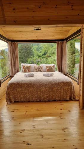 a large bed in a room with a large window at Keda Horizon cottage in K'eda