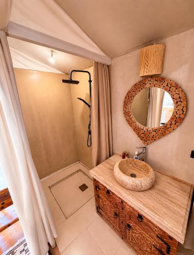 a bathroom with a wooden sink and a mirror at Sahara Nights Luxury Camp in Merzouga
