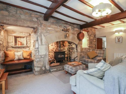 a living room with a stone fireplace in a room at Chamber End Fold in Skipton