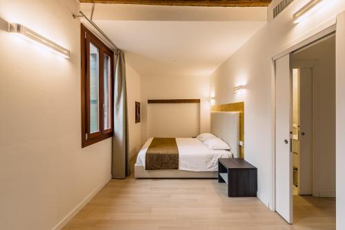 a bedroom with a bed and a window at Charming Palace Corte del Teatro in Venice