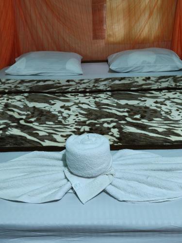 a hat and a shirt on a bed at Noupad sunset Guesthouse in Don Det