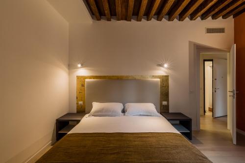 a bedroom with a large bed with two night stands at Charming Palace Corte del Teatro in Venice