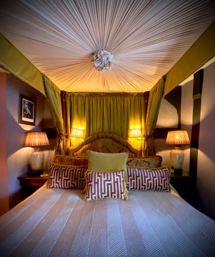 a bedroom with a canopy bed with two pillows at St Columbas Boutique BnB in Weobley