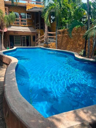 a large blue swimming pool in front of a house at Las Brisas House, Manzanillo in Manzanillo
