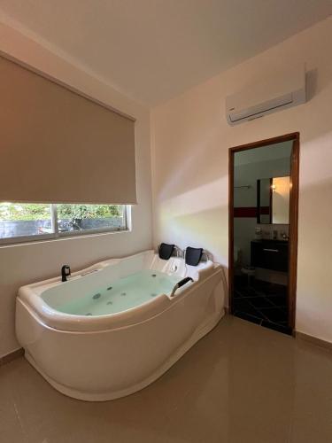 a large bath tub in a bathroom with a window at Selva del Rio San Jeronimo in San Jerónimo