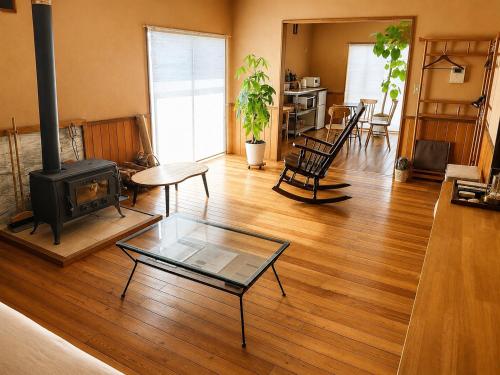 a living room with a wood floor and a fireplace at Secret Beach House MOKU in Fukutsu
