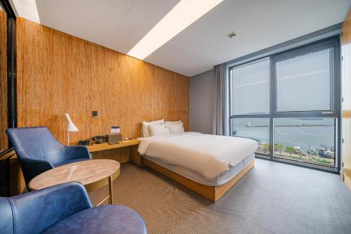 a hotel room with a bed and a large window at Louis Boutique Hotel in Changwon