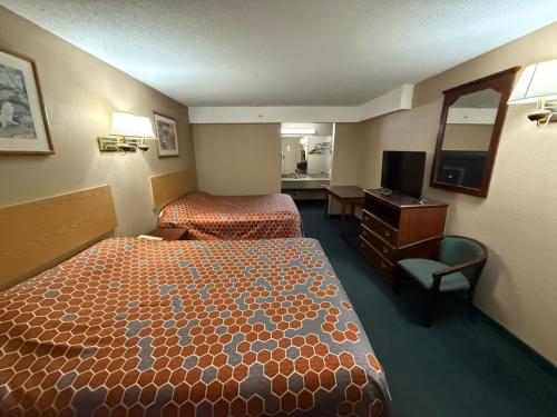 a hotel room with two beds and a desk at America's Best Inn & Suites Eureka in Eureka
