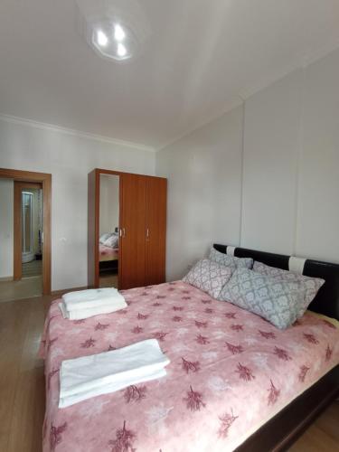 a bedroom with a large bed with a pink blanket at Antalya Premium Resort in Antalya