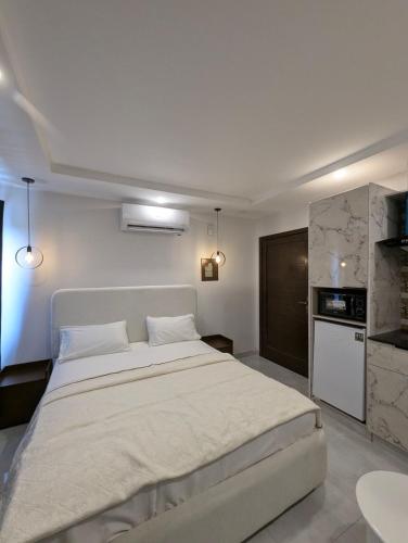a bedroom with a large white bed and a kitchen at Taj luxury hotel Quetta in Quetta