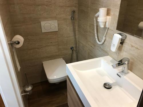 a bathroom with a white sink and a toilet at CenterCity Apartments in Prešov