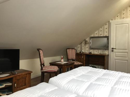 a bedroom with a bed and two chairs and a tv at CenterCity Apartments in Prešov