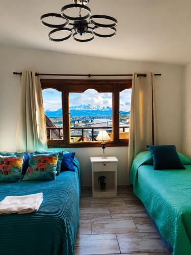 a bedroom with two beds and a window with a view at Ushuaia Magnifica,cabaña con balcon,luminosa y calida in Ushuaia