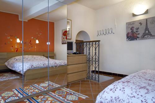 a bedroom with two beds and a mirror at Camera Dolcenotte in Orta San Giulio