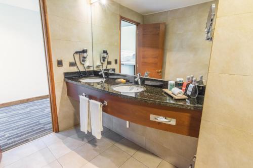 a bathroom with two sinks and a large mirror at MDS Hotel Concepción in Concepción