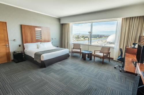 a hotel room with a bed and a large window at MDS Hotel Concepción in Concepción