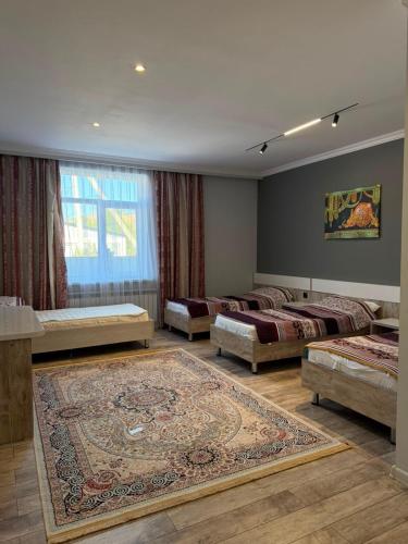 a room with three beds and a rug at Saty Guest House in Saty