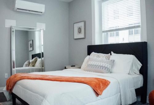 a bedroom with a large white bed with an orange blanket at Cantlley Noewsy in Wilmington