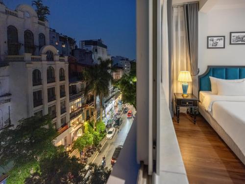a hotel room with a bed and a view of a city at Ritana Boutique Hotel & Spa in Hanoi