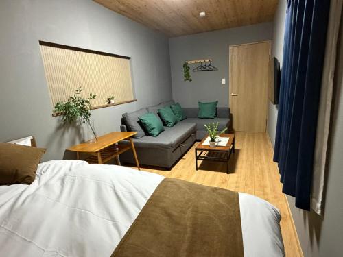 a living room with a couch and a living room with a bed at OZ Fuji in Fujiyoshida
