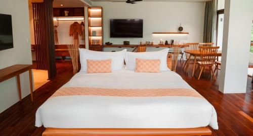ein Schlafzimmer mit einem großen weißen Bett und Kissen in der Unterkunft FCC Angkor by Avani in Siem Reap