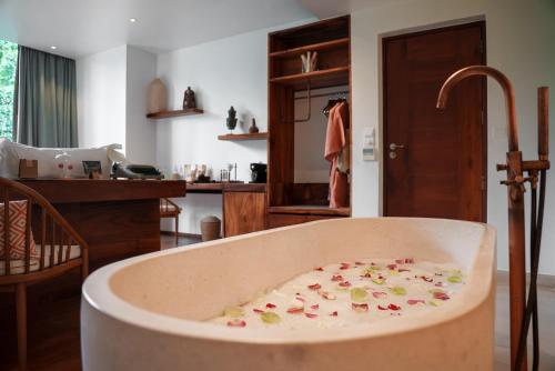 eine mit Blumen gefüllte Badewanne in einem Zimmer in der Unterkunft FCC Angkor by Avani in Siem Reap