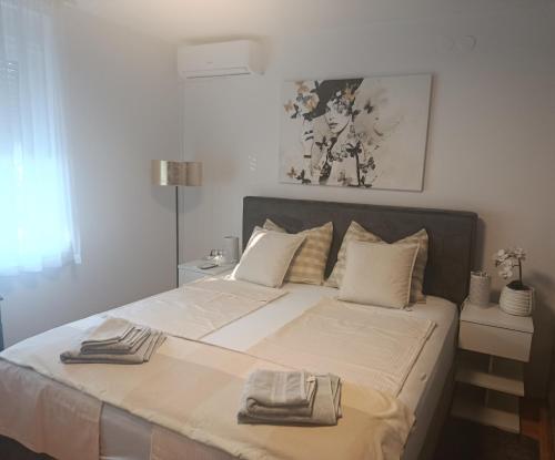 a bedroom with a large bed with two towels on it at Guest house Gloria in Šilo