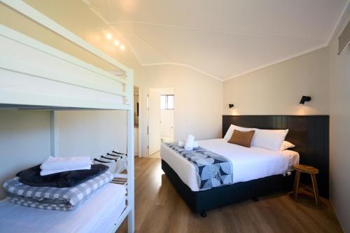 a bedroom with a bed and a bunk bed at Pine Country Caravan Park in Mount Gambier