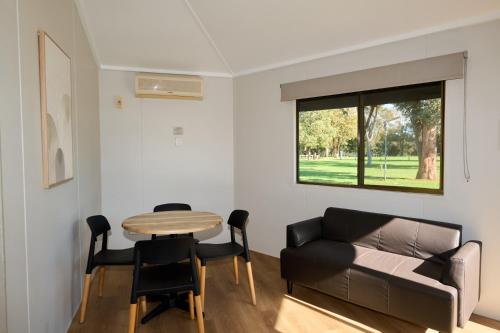 a living room with a couch and a table at Pine Country Caravan Park in Mount Gambier