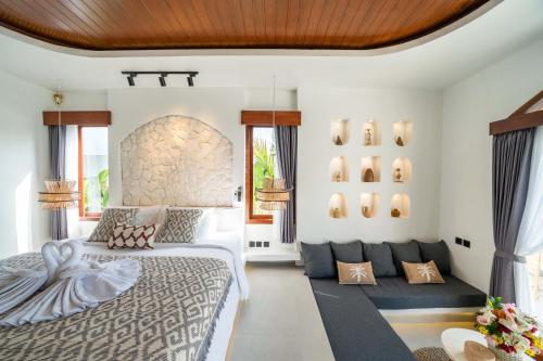 a bedroom with a large bed and a couch at Casa Maddu in Tegalalang