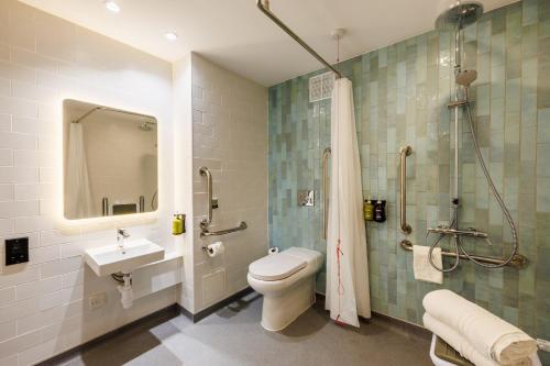 a bathroom with a toilet and a sink and a shower at Holiday Inn Stevenage by IHG in Stevenage