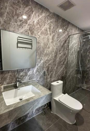 a bathroom with a toilet and a sink and a mirror at Đảo Ngọc Retreat in Quang Ninh