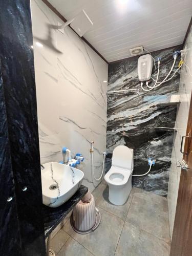 a bathroom with a sink and a toilet in it at Lohith International in Shimoga