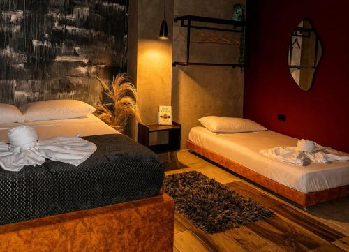 a bedroom with two beds and a mirror at Hotel Boutique Urban in San Gil