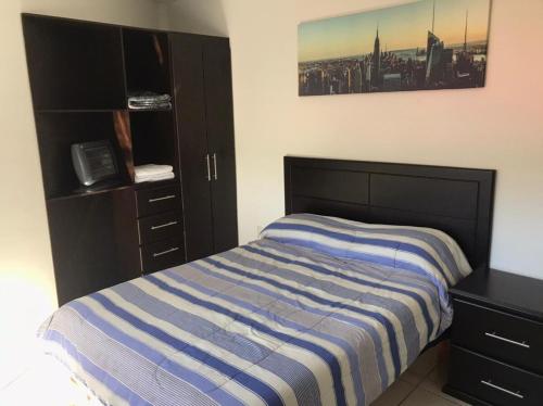 a bedroom with a bed and a dresser at Beautiful Apartment Executive 3 in Guadalupe