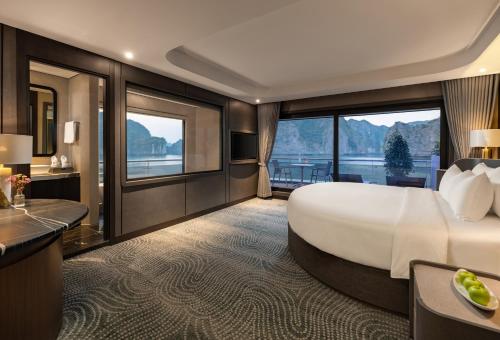 a hotel room with a large bed and a balcony at M'Gloria Cruise by HAG in Ha Long