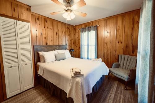a bedroom with a bed and a fan and a chair at Turn On Inn in Lake Village