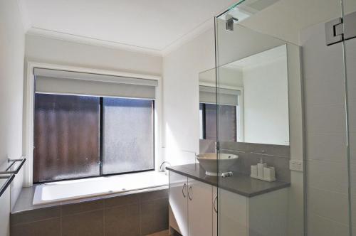 a bathroom with a sink and a large window at Plovers Rest in Inverloch
