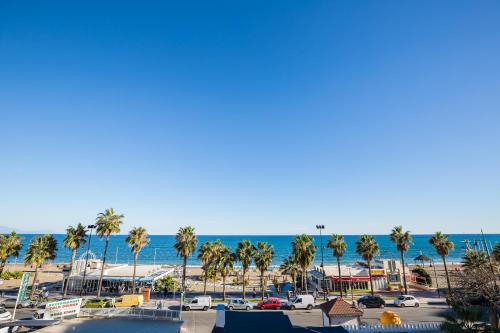 vistas a una playa con palmeras y al océano en Beatriz Charming Hostal, en Torremolinos