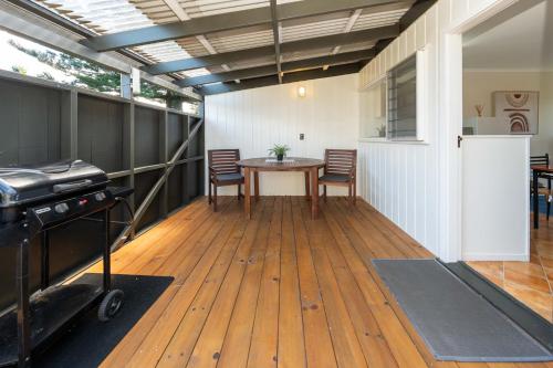 a room with a table and chairs and a grill at Cascade Garden Apartments in Burnt Pine