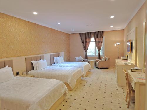 a hotel room with two beds and a desk at Basra Touristic Hotel in Al Başrah