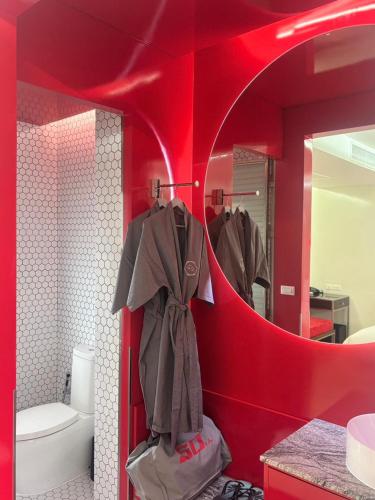 a bathroom with a red wall with a mirror at The 50th Uthai Thani in Uthai Thani