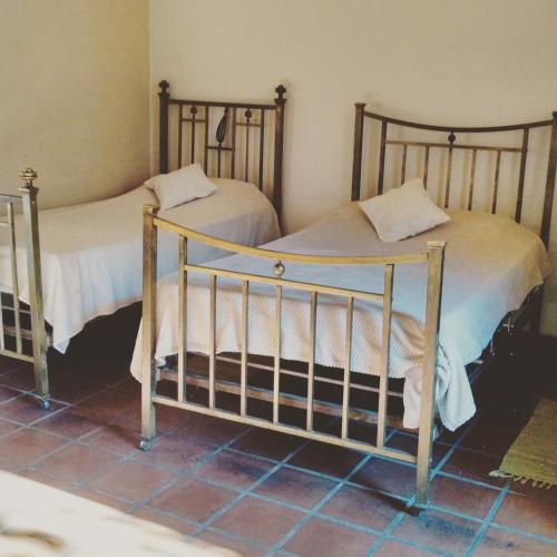 two twin beds in a room with at Vieja Posada Hotel Histórico in Cafayate