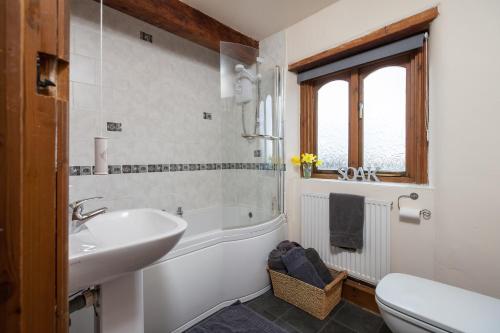 Green HammertonにあるSkipbridge Farm Cottagesのバスルーム(シンク、バスタブ、トイレ付)